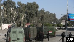 Polisi anti huru hara Mesir mengelilingi pintu masuk Universitas Al-Azhar saat bentrok dengan siswa yang mendukung Ikhwanul Muslimin, di distrik Nasr City, Timur Kairo, pada tanggal 27 Desember 2013.