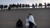 Migrantes son cargados en una camioneta mientras son procesados por la Patrulla Fronteriza después de cruzar ilegalmente el río Bravo desde México hacia EEUU en Texas, el 26 de agosto de 2022.