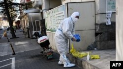 Un trabajador que usa equipo de protección personal (EPP) durante la pandemia de covid-19 en una calle de Beijing, China, el 11 de diciembre de 2022.