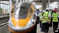 Pekerja dan pejabat memeriksa unit Comprehensive Inspection Train (CIT) yang baru diluncurkan di stasiun KA Cepat Jakarta-Bandung di Tegalluar, Jawa Barat, Kamis, 13 Oktober 2022. (Foto: AP/Dita Alangkara)