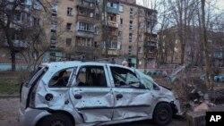 A damaged car is seen at the scene of Russian shelling in Kyiv, Ukraine, Dec. 31, 2022. (