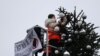 Para aktivis "Letzte Generation" (Generasi Terakhir) memotong pucuk pohon Natal di Gerbang Brandenburg, di Berlin, Jerman, 21 Desember 2022. (REUTERS/Christian Mang)