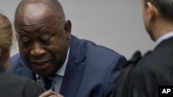 L'ancien président ivoirien Laurent Gbagbo accueille son équipe de défense lors de son entrée dans la salle d'audience de la Cour pénale internationale à La Haye, aux Pays-Bas, le 15 janvier 2019, où les juges ont acquitté Gbagbo et Charles Ble Goude.