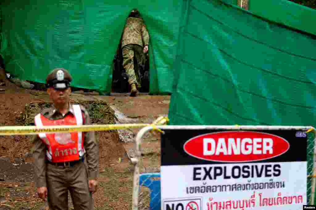 An Australian soldier enters the Tham Luang cave complex, where 12 schoolboys and their soccer coach are trapped inside a flooded cave, after Thailand's government instructed members of the media to move out urgently, July 8, 2018.