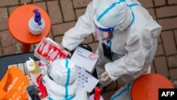 melakukan tes asam nukleat untuk virus corona bagi warga di Jilin di provinsi Jilin timur laut China pada 12 Maret 2022. (Foto: AFP)