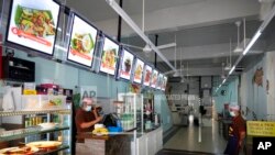 File -Restaurant staffs wearing face mask wait for customers in Kuala Lumpur, Malaysia, June 28, 2021.