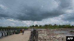 Un hombre camina sobre el puente derrumbado de la ciudad de La Fortuna en el estado de Zulia, Venezuela, el 10 de septiembre de 2021.