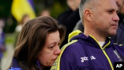 Natalia Kurkchy apoya la cabeza en el hombro de su esposo, Peter, durante una protesta por la invasión rusa de Ucrania celebrada en el Capitolio en Sacramento, California, el 24 de febrero de 2022.