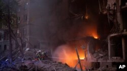 Petugas pemadam kebakaran berusaha memadamkan api di Kyiv, Ukraina pada Kamis, 28 April 2022. Rusia melancarkan serangan di wilayah luas Ukraina pada Kamis, membombardir Kyiv selama kunjungan kepala PBB. (Foto: AP/Emilio Morenatti)