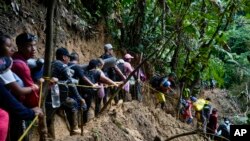 ARCHIVO - Migrantes, en su mayoría venezolanos, cruzan el Tapón del Darién desde Colombia hacia Panamá, con la esperanza de llegar a Estados Unidos, en octubre de 2022