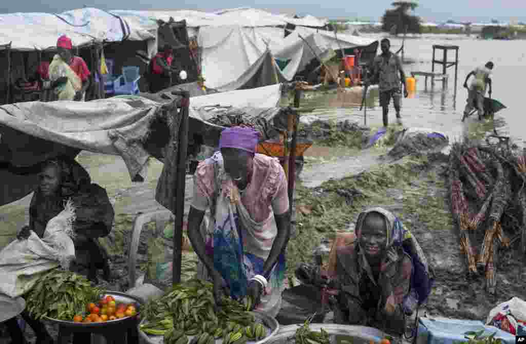 Des déplacées Sud Soudanaises étalent des produits qu’elles vendent dont une partie est maintenant cultivé dans un camp de fortune pour déplacés situé dans la Mission des Nations Unies au Soudan du Sud (MINUSS) base dans la ville de Bentiu, au Soudan du Sud le lundi 22 septembre 2014. (AP Photo / Matthew Abbott)