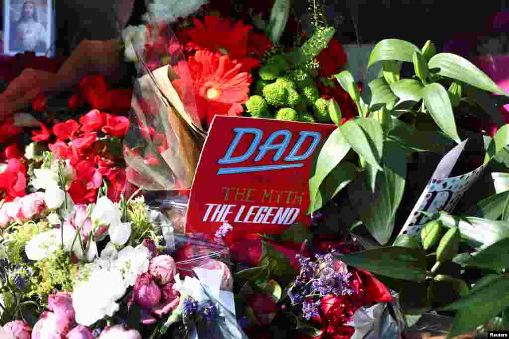 A father's day card sits among flowers left for the victims of the Grenfell apartment tower fire in North Kensington, London.