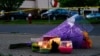 Flores y velas, en el exterior del supermercado escenario de una balacera, en Buffalo, Nueva York, el 15 de mayo de 2022. (AP Foto/Matt Rourke)