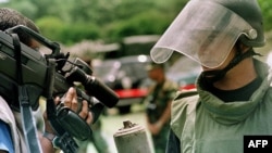 ARCHIVO. Un ingeniero de combate (derecha) muestra a la prensa una mina antipersonal encontrada durante una operación de desminado patrocinada por la Organización de los Estados Americanos (OEA) el 22 de agosto de 2000 en San Marcos de Colón, Honduras.
