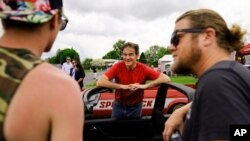 Mehmet Oz, candidato republicano al Senado de EEUU en Pensilvania, se reúne con los asistentes durante una visita a una exhibición de autos en Carlisle, Pensilvania, el sábado 14 de mayo de 2022. (AP Photo/Matt Rourke)