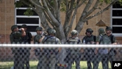 ARCHIVO - Agentes del orden están parados afuera de la Escuela Primaria Robb tras un tiroteo fatal el 24 de mayo del 2022 en Uvalde, Texas.