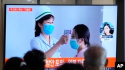 14일 한국 서울 시내 철도역에서 북한 코로나 관련 뉴스가 방송되고 있다. 