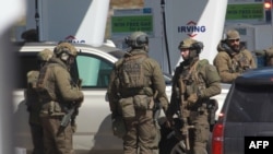 Members of the Royal Canadian Mounted Police (RCMP) tactical unit confer after the suspect in a deadly shooting rampage was neutralized at the Big Stop near Elmsdale, Nova Scotia, Canada, April 19, 2020.