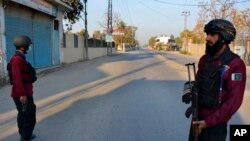 Petugas keamanan berjaga di jalan yang diblokir menuju pusat kontra-terorisme di mana beberapa tahanan Taliban Pakistan menyandera petugas polisi dan lainnya di dalam kompleks, di Bannu, distrik di provinsi Khyber Pakhtunkhwa Pakistan, Senin, 19 Desember 2022.(AP/Muhammad Hasib)
