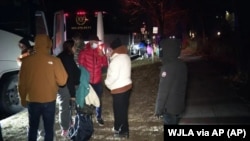 Familias de migrantes suben a un autobús para transportarlos desde los alrededores de la residencia de la vicepresidenta de EE.UU Kamala Harris a una iglesia del área después de haber llegado a Washington, la noche del 24 de diciembre de 2022.
