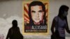 ARCHIVO - Peatones caminan cerca de un afiche que pide libertad para el empresario colombiano y enviado especial de Venezuela Alex Saab, en Caracas, Venezuela, el 9 de septiembre de 2021. 