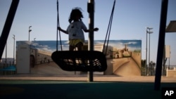 A girl swings next to a painted concrete bomb shelter, at a public park in Sderot, Israel, Aug. 2, 2021, the place in Israel hit hardest by Palestinian rocket fire.
