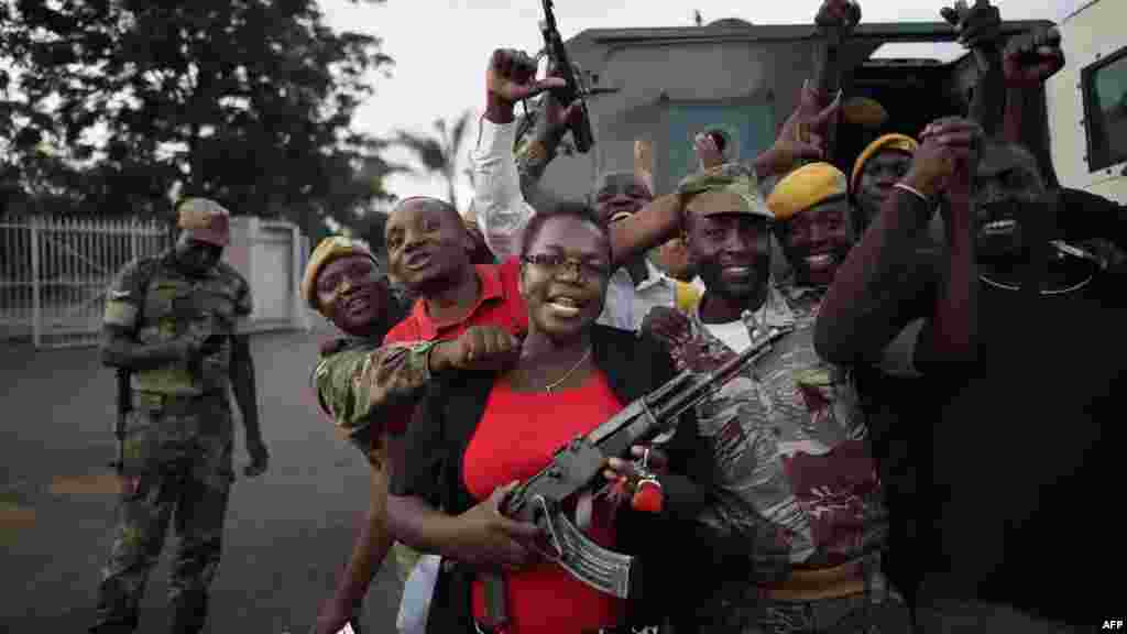 La foule célèbre avec des soldats après l'annonce de la démission du président du Zimbabwe, 21 novembre 2017.