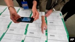 ARCHIVO - Un observador fotografía boletas provisionales del condado de Lehigh mientras continúa el conteo de votos en las elecciones generales, del 6 de noviembre de 2020, en Allentown, Pensilvania, EEUU.
