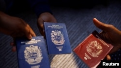Migrantes venezolanos muestran sus pasaportes en Ciudad Juárez, México, el 16 de octubre 2022.