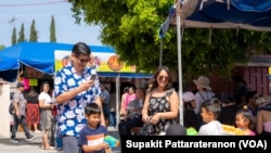 People splash water on each other but bathe the Buddha Praying for blessings for good fortune in life during Songkran and Thai New Year Celebration event at Wat Thai (Temple) Los Angeles in North Hollywood, CA