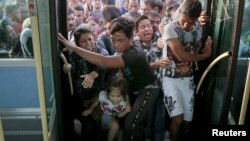 Refugees and migrants push each other as they try to board a bus following their arrival onboard the Eleftherios Venizelos passenger ship at the port of Piraeus, near Athens, Greece, Sept. 7, 2015.