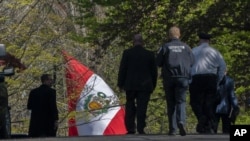 Agentes de la Policía Metropolitana de Washington caminan cerca de la residencia del embajador peruano el miércoles 20 de abril de 2022, en el noroeste de Washington, D.C. 
