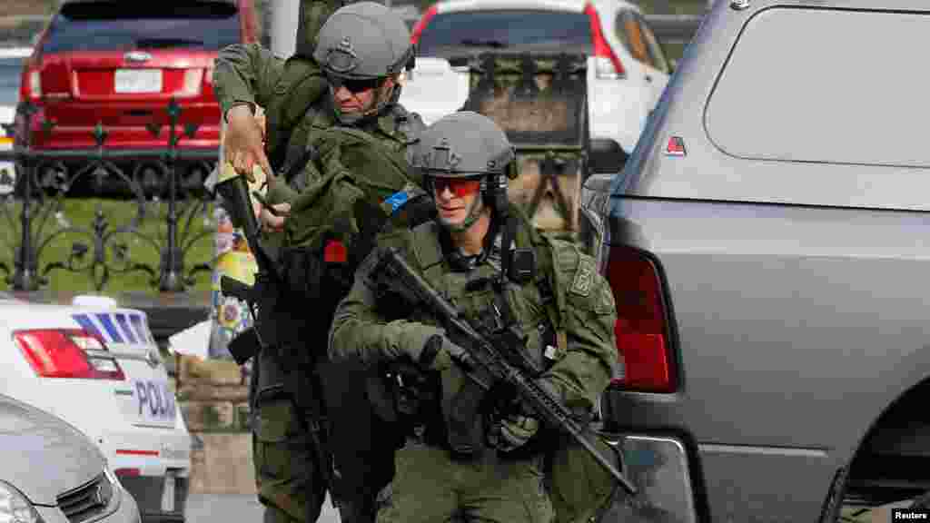 Des agents de la GRC, armés jusqu'aux dents, lancent un assaut à l'édifice du Parlement après une fusillade à Ottawa, le 22 Octobre 2014.