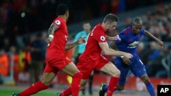 Jordan Henderson, centre, de Liverpool défie Ashley Young, à droite, de Manchester United lors d'un match de la Premier League anglaise au stade Anfield à Liverpool, en Angleterre, le 17 octobre 2016.