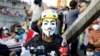 An Iraqi demonstrator carries bottles of soda used to neutralize tear gas during an anti-government protest in Baghdad, Iraq, Nov. 1, 2019. 