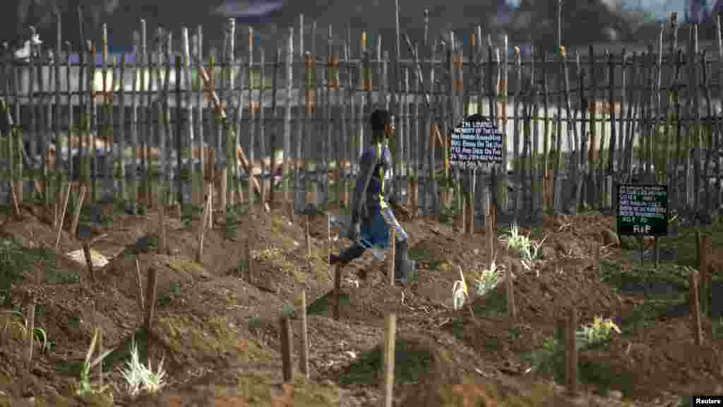 Un fossoyeur marche à travers les fosses nouvellement creusées pour l’enterrement des victimes d'Ebola dans un cimetière de Freetown, 4 décembre 2014. REUTERS / Baz Ratner