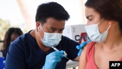 A student receives a dose of the Pfizer COVID-19 vaccine during a City of Long Beach Public Health COVID-19 mobile vaccination clinic at the California State University Long Beach (CSULB) campus on Aug. 11, 2021, in Long Beach, California.
