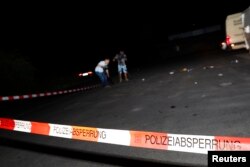 Cameramen film at the scene where a man was shot dead by the police after attacking passengers on a train with an axe near the city of Wuerzburg, Germany, July 19, 2016.