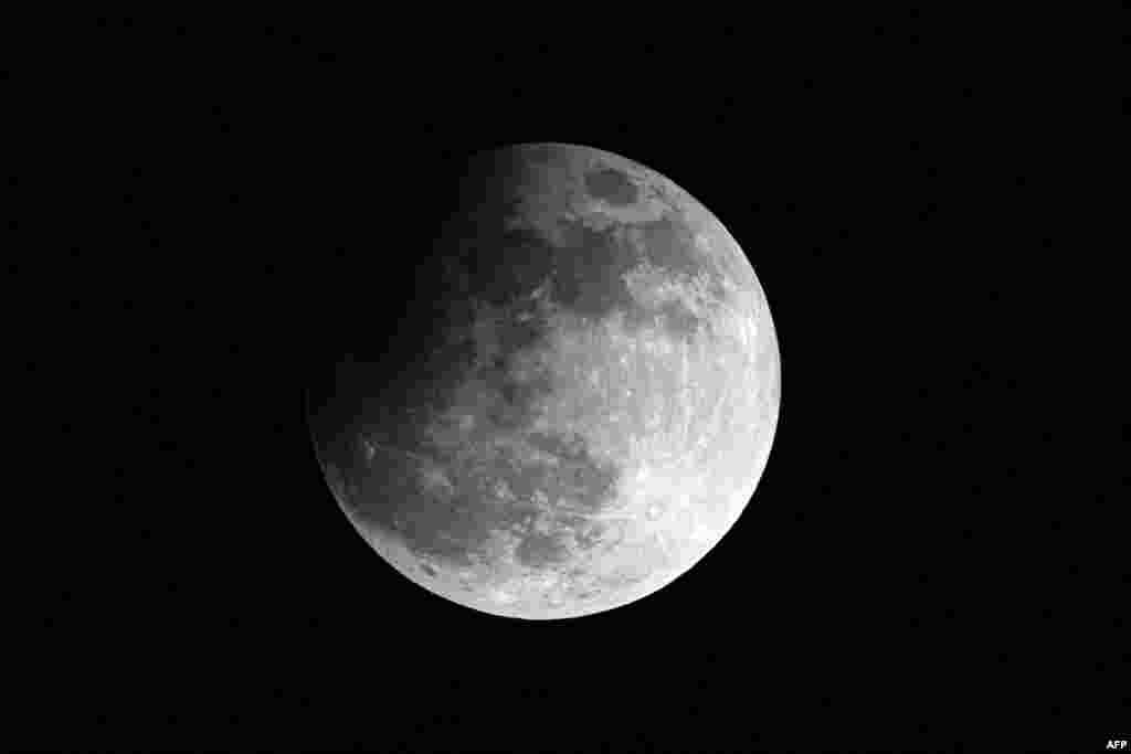 Una luna llena, también llamada "Luna de la cosecha" y una de las cuatro superlunas del año, se eleva sobre Caracas durante un eclipse lunar parcial, a última hora del 17 de septiembre de 2024. 