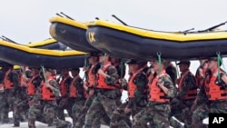 ARSIP – Para peserta latihan Navy SEAL membawa perahu karet di Pangkalan Amfibi Coronado, di Coronado, California (foto: AP Photo/Denis Poroy, Arsip)