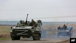 Kendaraan militer Rusia bergerak di jalan raya di kawasan yang dikuasai pasukan separatis dukungan Rusia di dekat Mariupol, Ukraina, Senin, 18 April 2022. (Foto: AP)
