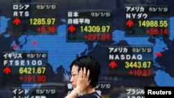 Papan elektronik di depan papan sekuritas di Tokyo ini menunjukkan kenaikan rata-rata harga saham Nikkei Jepang (atas tengah) dan harga-harga saham lainnya pada hari Jumat, 5 Juli 2013.