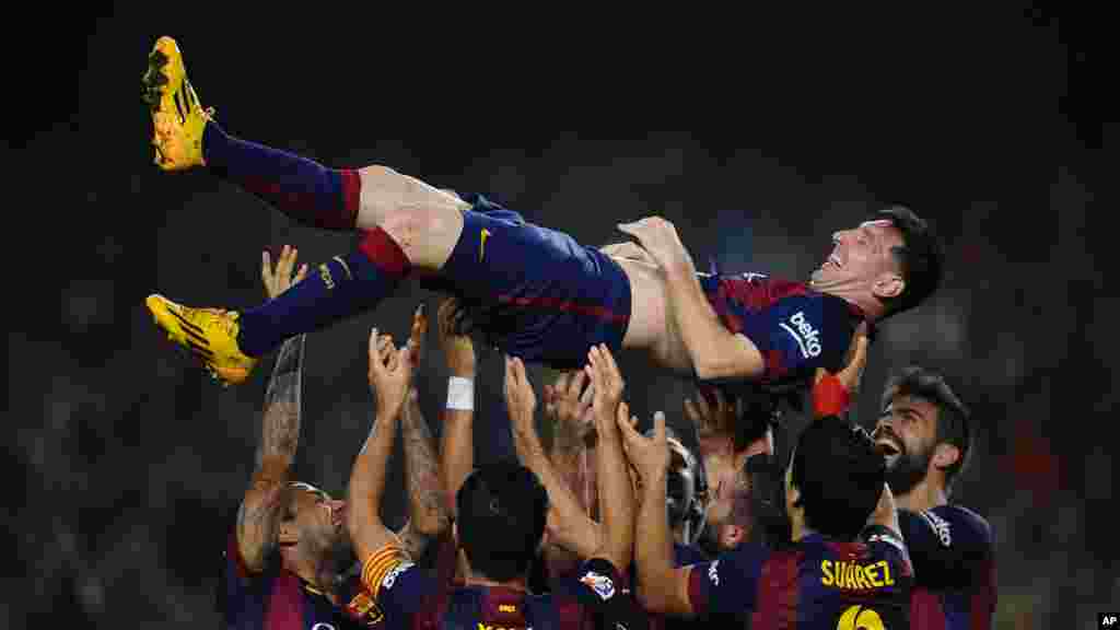 L'argentin Lionel Messi du FC Barcelone est soulevé par ses coéquipiers après avoir marqué contre Séville lors d'un match de football de La Liga entre le FC Barcelone et Séville, au stade Camp Nou à Barcelone, Espagne.