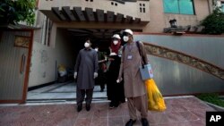 Petugas medis Pakistan melakukan tes virus Corona terhadap warga dari rumah ke rumah. 