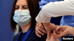 A woman receives the AstraZeneca vaccine under the COVAX scheme against the coronavirus disease in Pristina, Kosovo, March 29, 2021.
