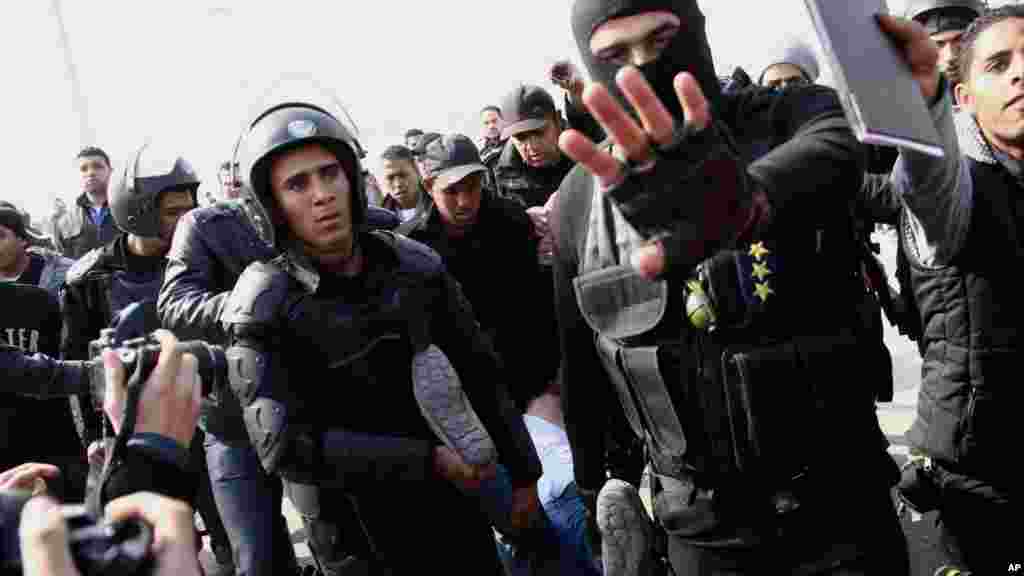 Riot police officers detain a man following clashes between supporters of Egypt's ousted President Mohamed Morsi and police in Cairo, Jan. 8, 2014.