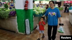 FILE - Customers shop for groceries at a morning market in Beijing, Aug. 9, 2023.