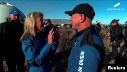 Miliarder Jeff Bezos, pendiri Amazon.com Inc, berbincang dengan Laura Shepard Churchley, putri astronaut Amerika pertama, Alan Shepard dan kru wahana antariksa New Shepard milik Blue Origin setelah tiba di tempat peluncuran Launch Site One di West Texas, Sabtu, 11 Desember 2021