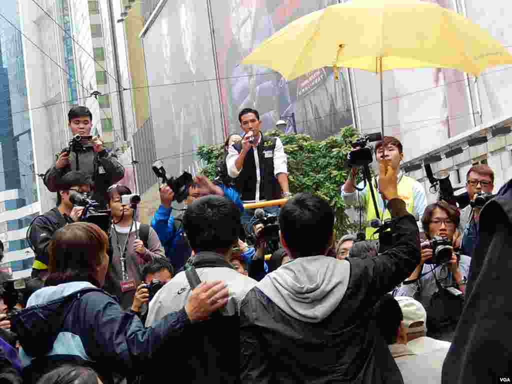 泛民立法會議員陳家洛(右一)在警方展開拘捕行動前高舉黃色雨傘