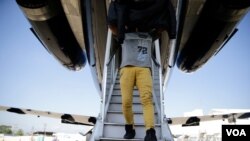 Un migrante hondureño retornado desde México desciende la escalerilla del avión que lo llevó de vuelta a su país.